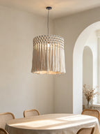 Hung beneath an arched doorway in a light dining nook, this Clérachic pendant catches sunlight over a round table.