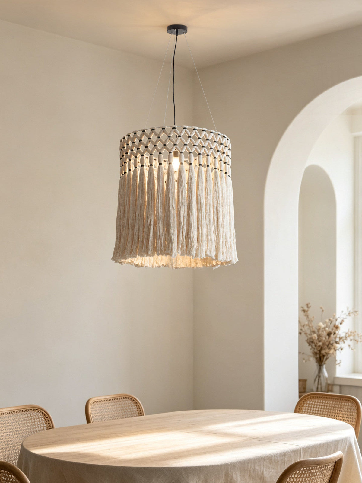 Hung beneath an arched doorway in a light dining nook, this Clérachic pendant catches sunlight over a round table.