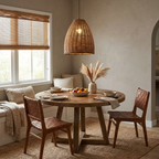 Pampas grass centres a round wood table in a breakfast nook lit by this rattan Clérachic pendant.