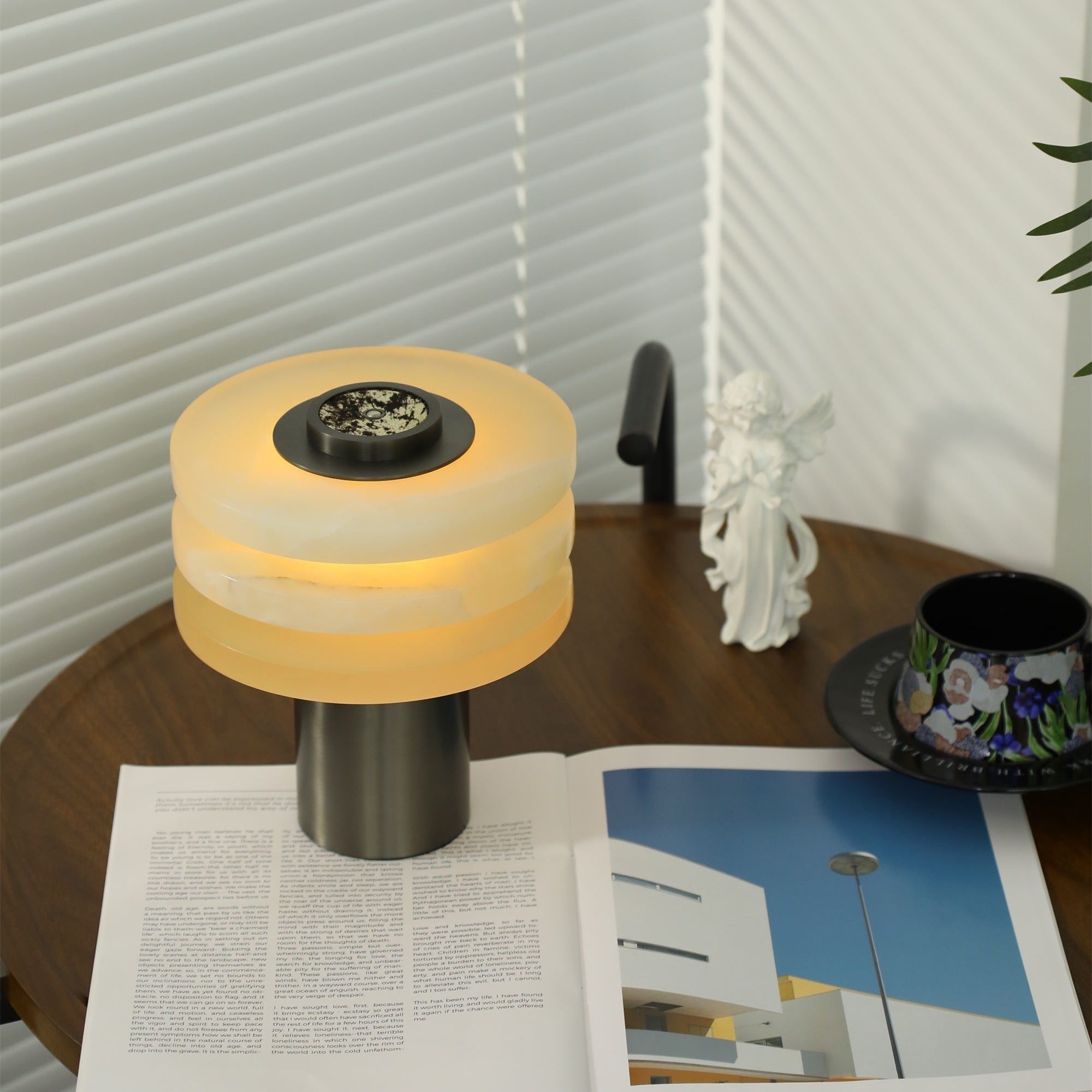 Looking down on the lit lamp, warm light ringing the top alabaster disc around the speckled stone dial