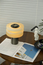 The alabaster lamp lit warm and seen from above, showing the speckled stone dial set into its metal top cap