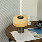 Three-quarter view of the lit lamp, warm light spilling from the gaps between the stacked stone tiers