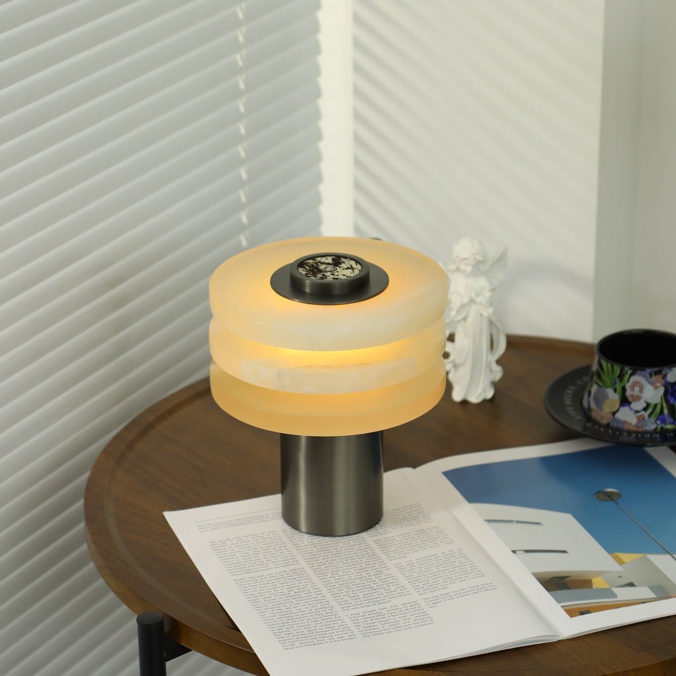 Three-quarter view of the lit lamp, warm light spilling from the gaps between the stacked stone tiers