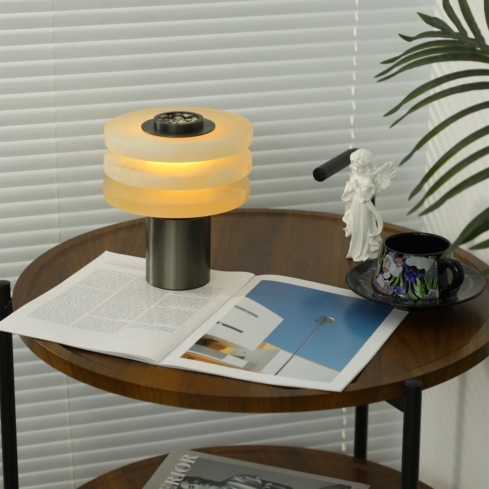 The cordless lamp lit on a two-tier walnut side table, with no power cable running from its base