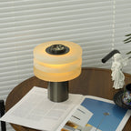 Angled view of the lit lamp with tiers stacked close, the dark stone dial tilted toward the camera