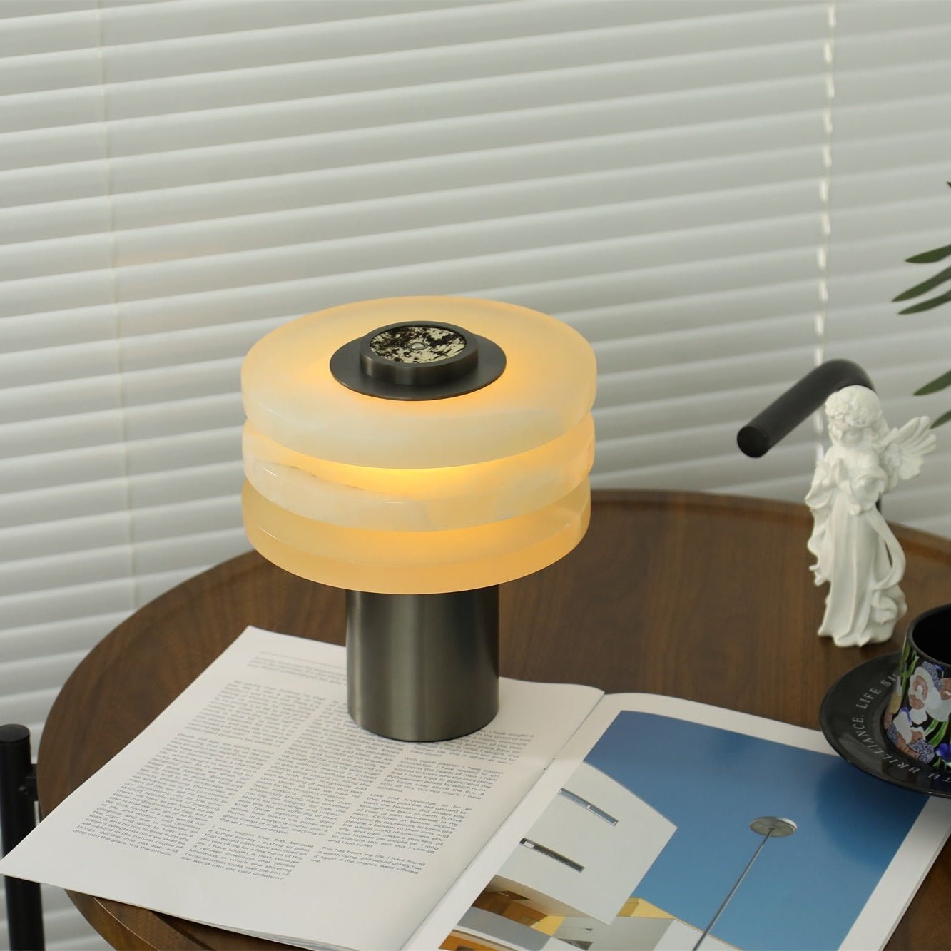 Angled view of the lit lamp with tiers stacked close, the dark stone dial tilted toward the camera