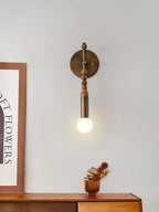 Antique brass and stone wall lamp lighting a styled interior