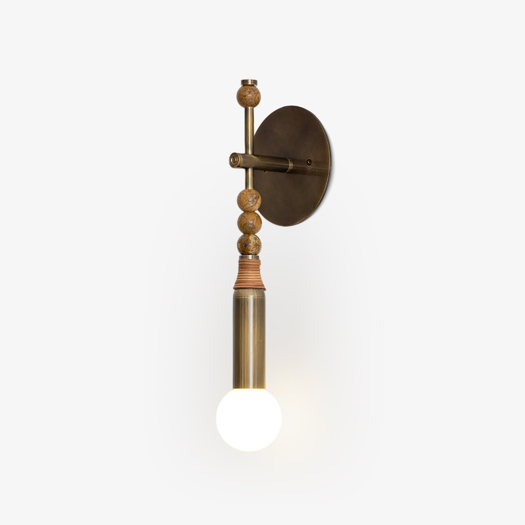 Antique brass wall sconce glowing in a styled bedroom