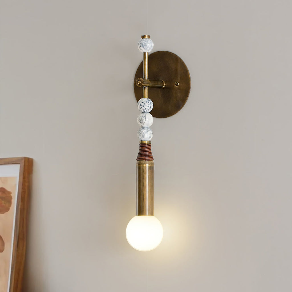 Brass and marble wall lamp lighting a hallway softly