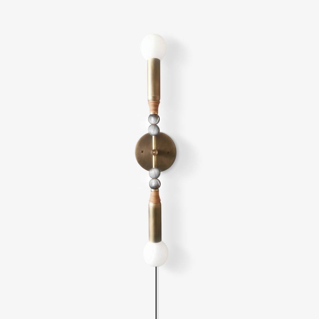 Clérachic wall light shown cropped to its upper half, white and grey stone beads threaded on the brass mounting rod.