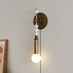 Clérachic plug-in wall lamp beside a framed picture, wood and marbled beads above a lit globe and hanging cord.