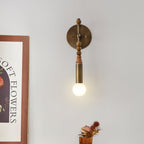 Antique brass wall sconce with warm light on a textured wall