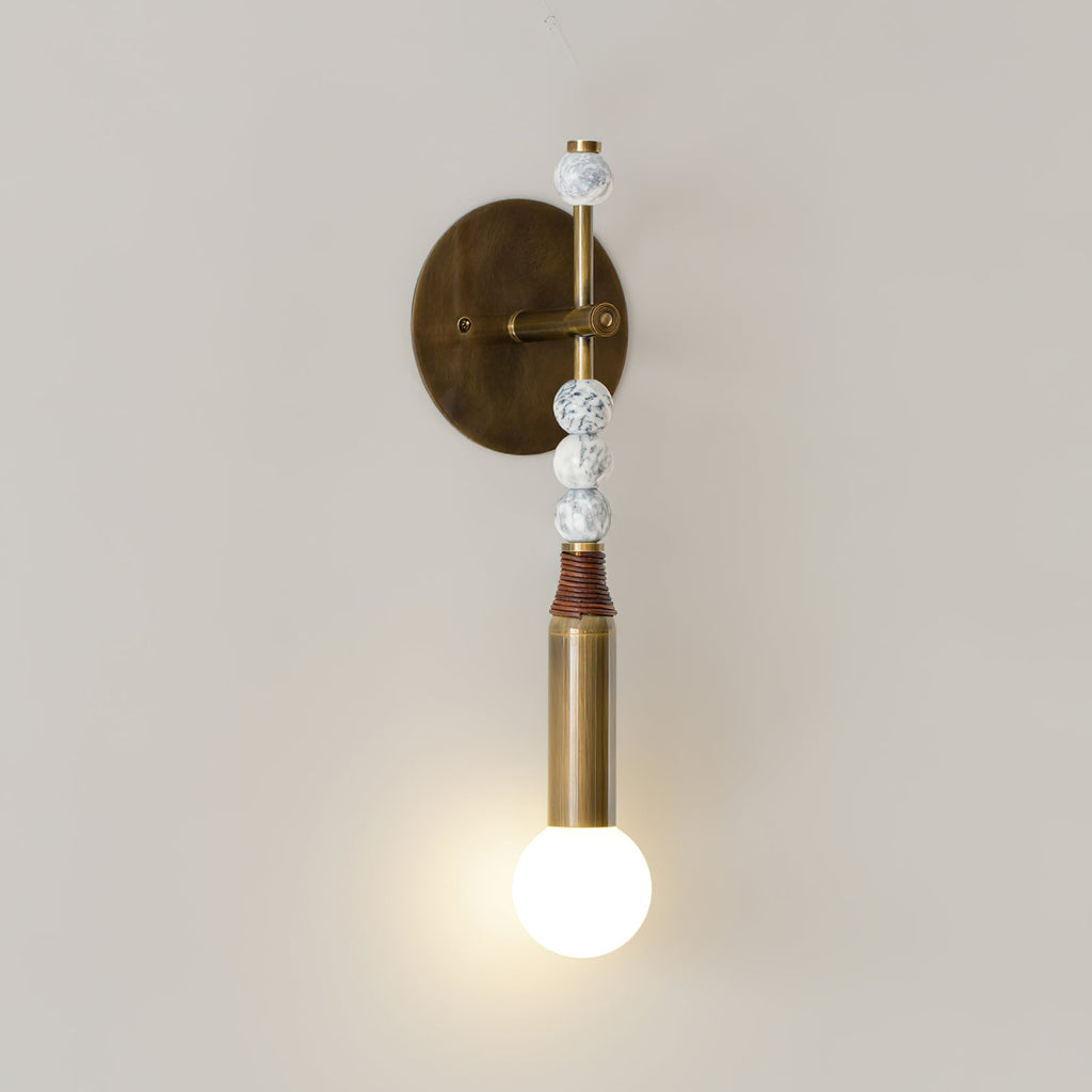 Antique brass wall lamp glowing warmly near a doorway