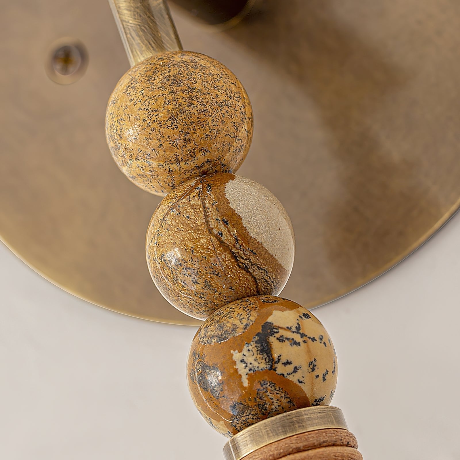 Brass wall sconce with marble accent lighting an entryway