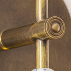 Brass wall lamp with marble accent glowing beside framed art