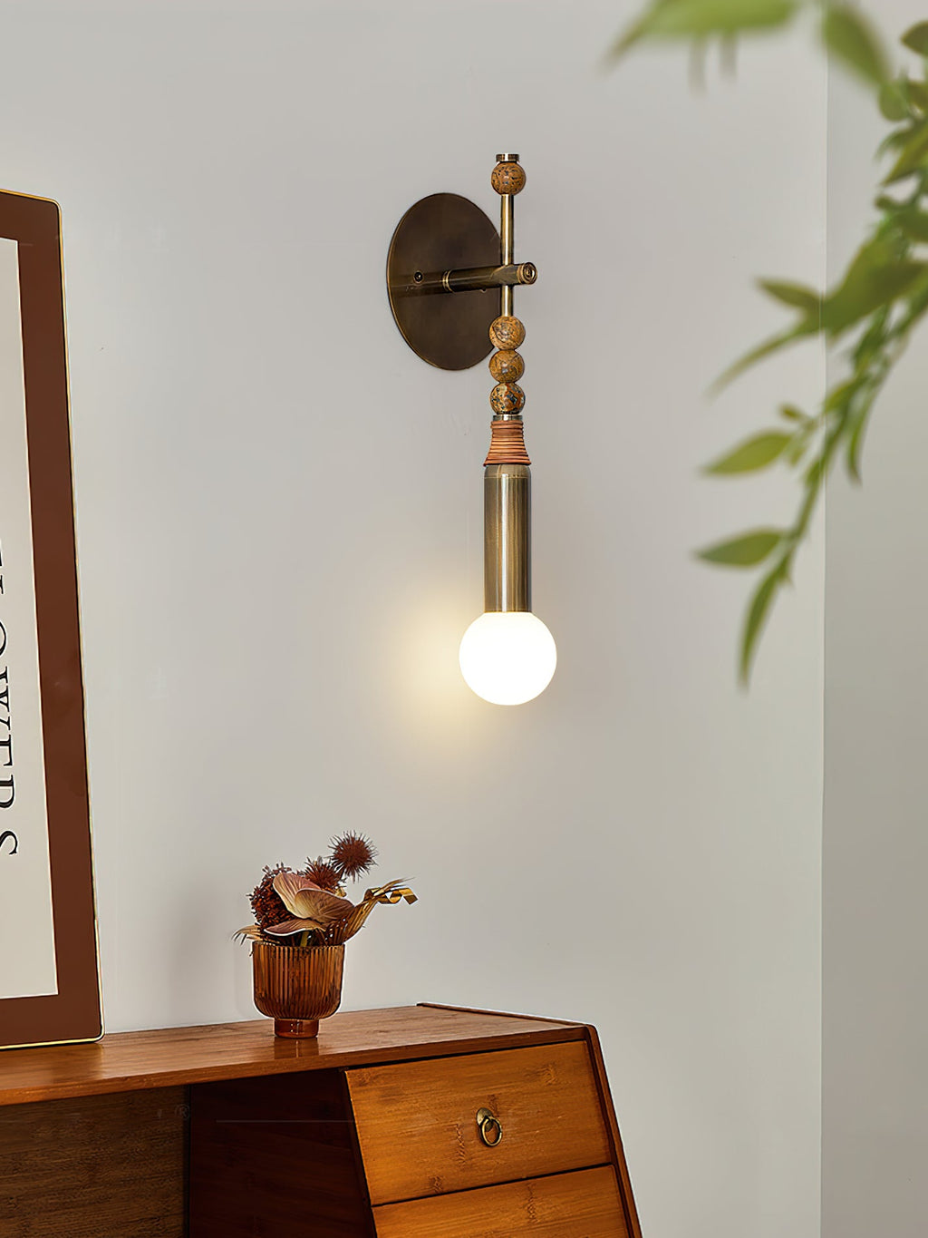 Brass wall lamp with marble accent glowing in a living space