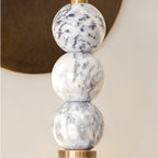 Brass and marble wall lamp casting warm uplight on plaster