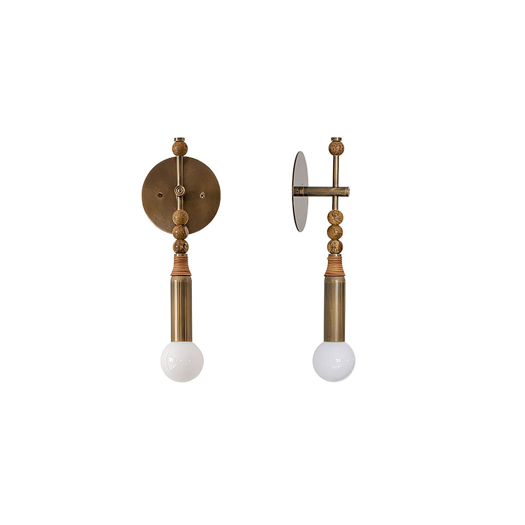 Antique brass wall sconce with stone detail in a refined hall