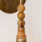 Brass and marble wall lamp shown from the side with warm glow