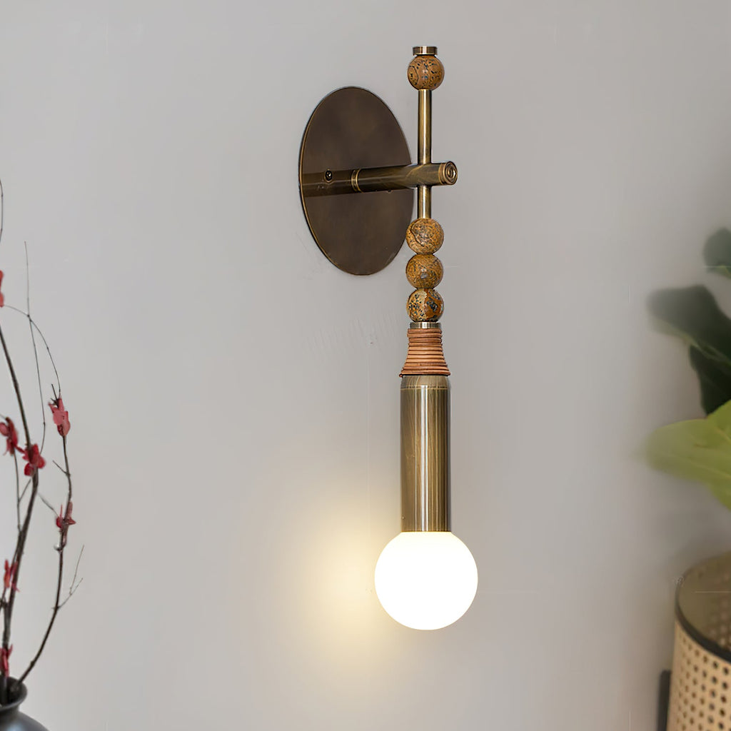 Antique brass wall lamp casting warm light on a bedroom wall