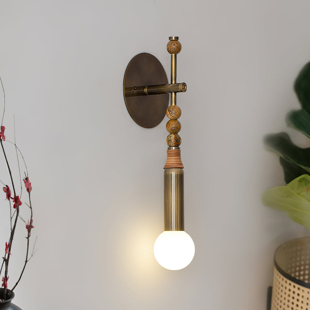 Brass and marble wall lamp glowing softly in a hallway