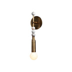 Brass wall sconce with black marble detail on a wall