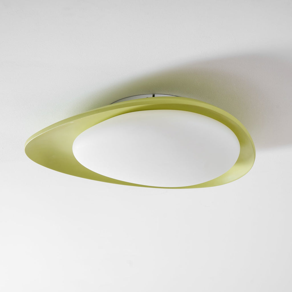 Seen from an angle, the green resin body of this Clérachic ceiling light frames a glowing oval diffuser.