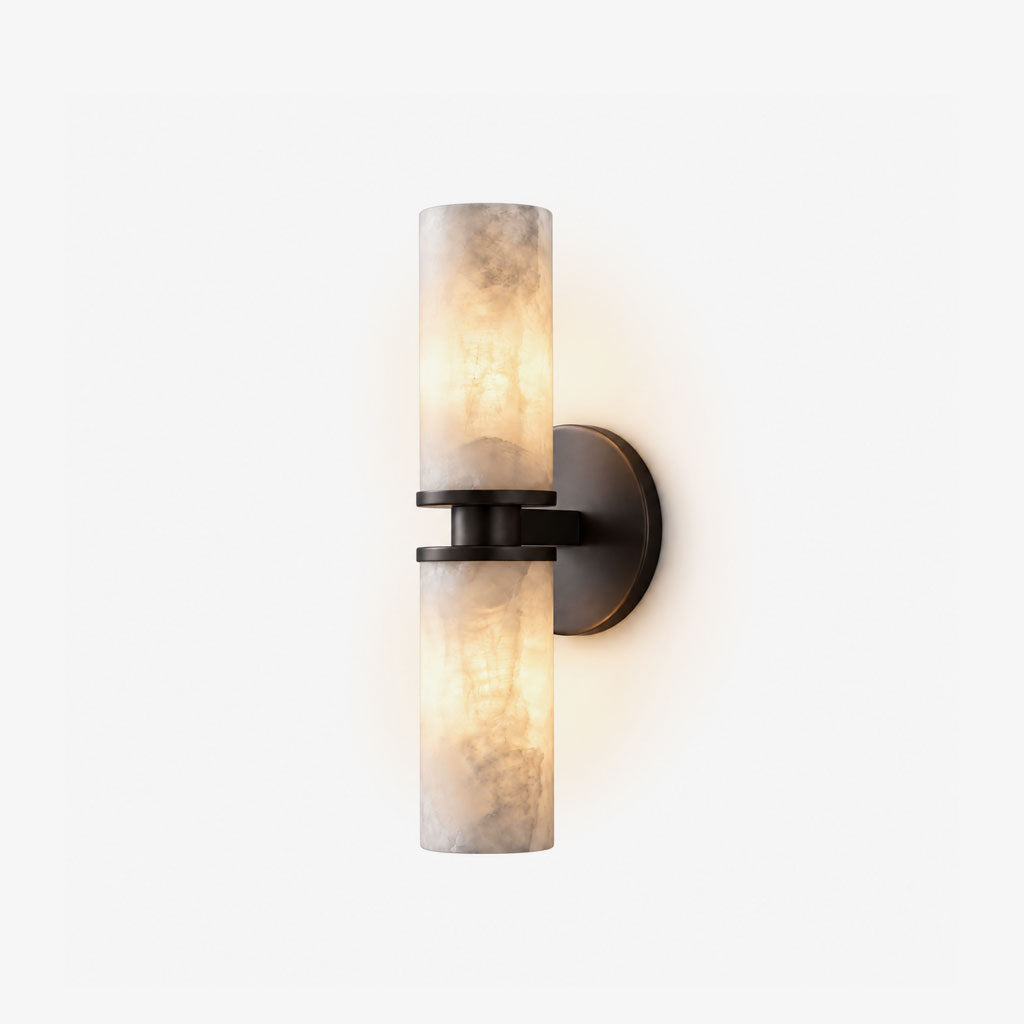 On a white backdrop, this Clérachic wall light in matte black shows its two lit alabaster tubes in full profile.