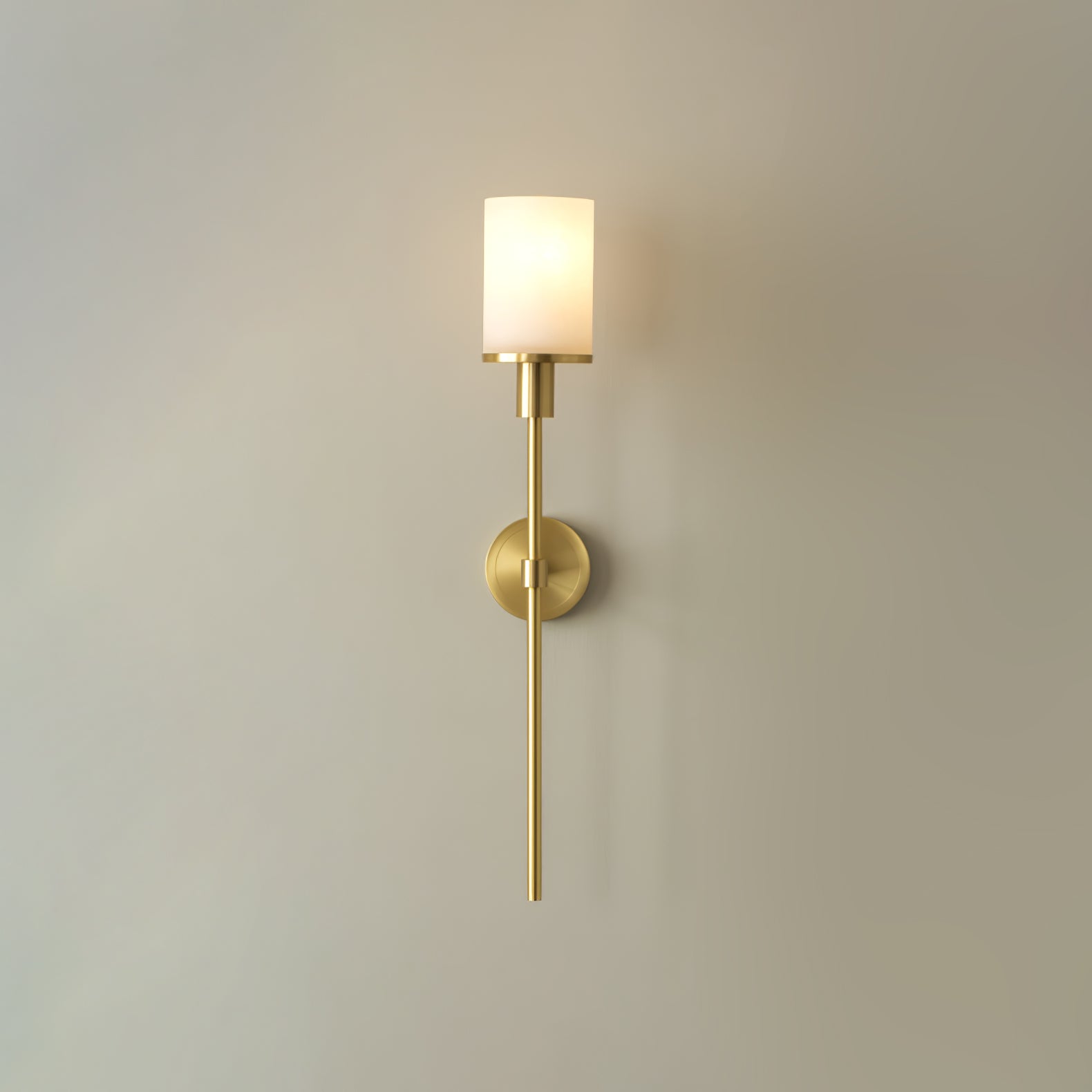 Clérachic brass alabaster sconce lit, the round backplate and small square cuff visible mid-stem