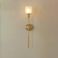Clérachic front view of the brass alabaster sconce, showing the slim tapered stem below the round wall plate