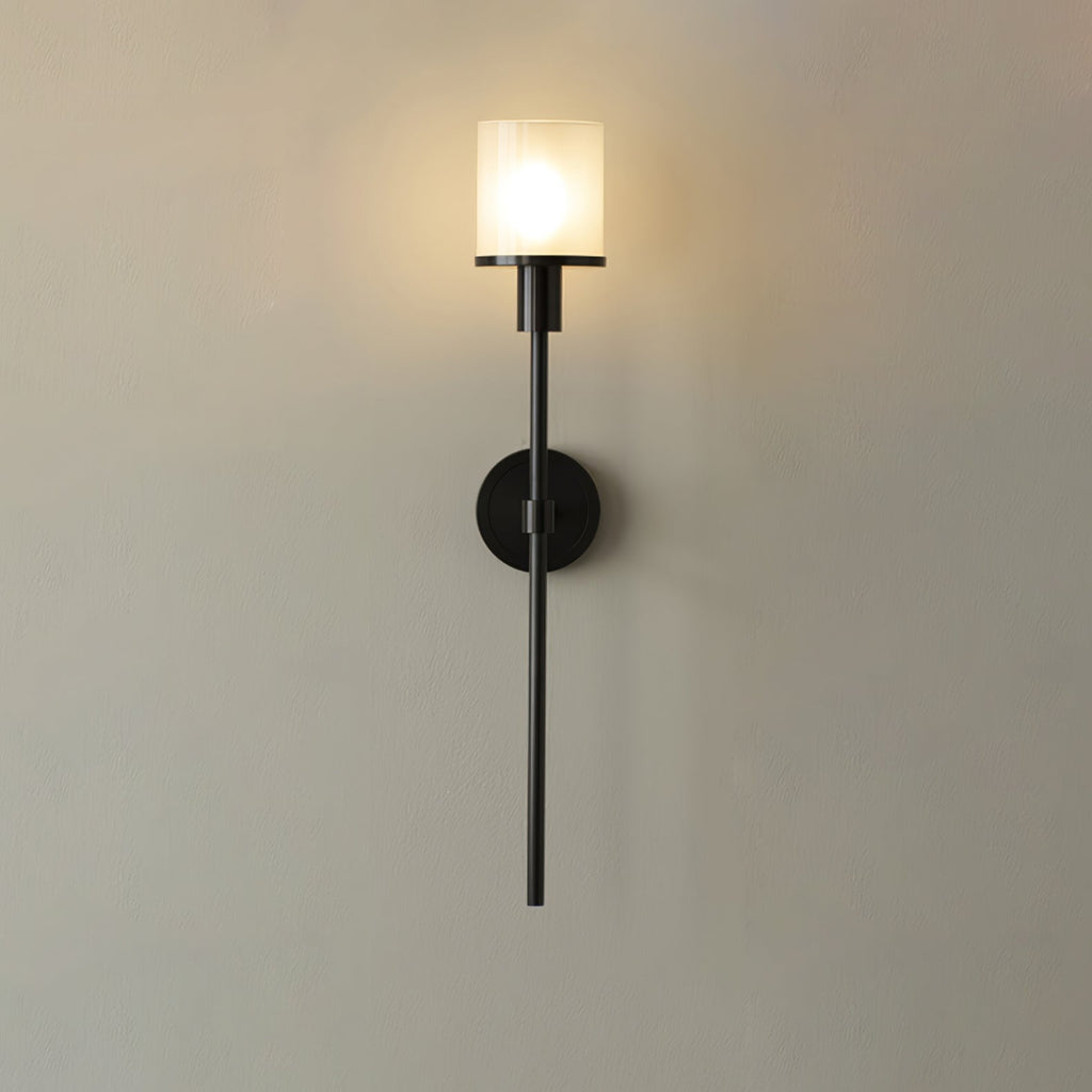 Clérachic black-finish version of the alabaster wall sconce, lit, its dark stem set against a warm cream wall