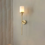 Clérachic brass alabaster sconce lit beside a sheer curtain, seen at an angle against a plain wall