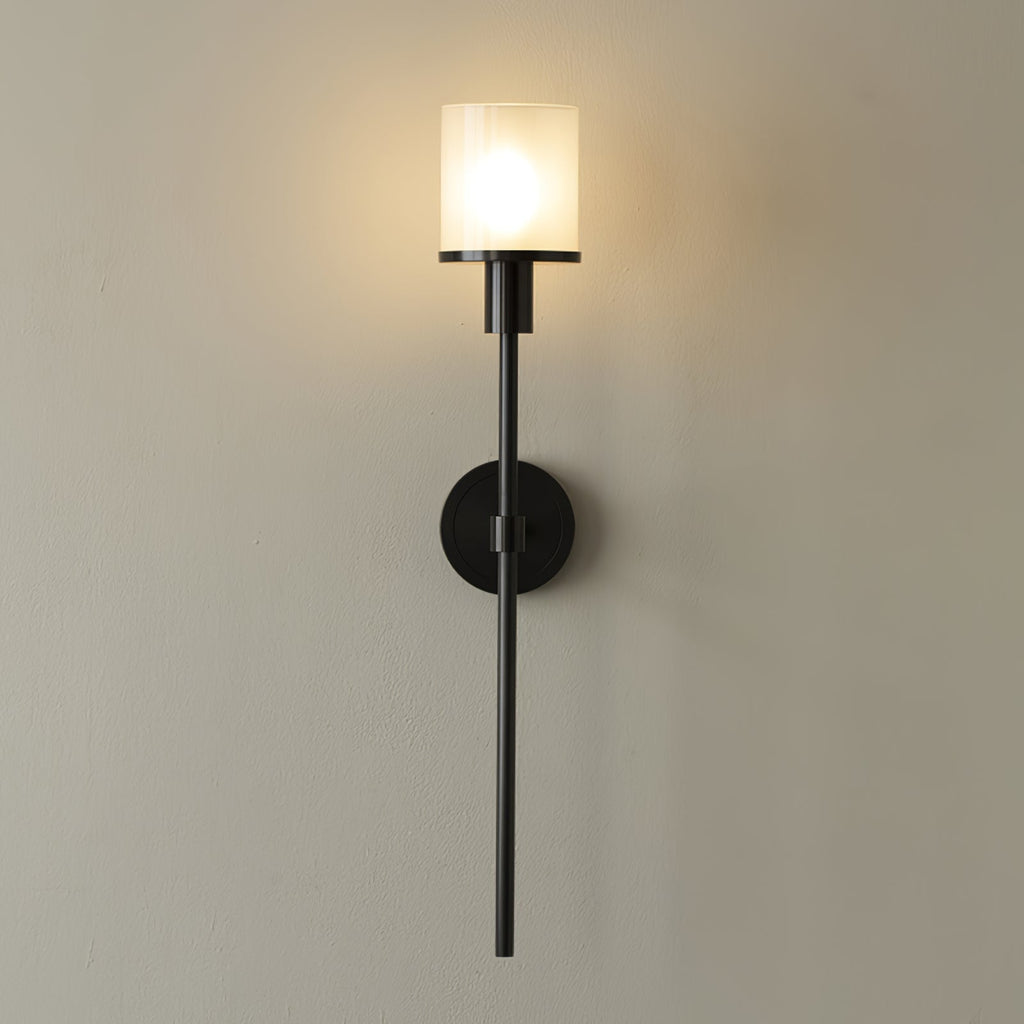 Clérachic black alabaster sconce lit, the clear outer glass sleeve visible around the frosted inner shade