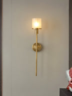 Clérachic brass alabaster sconce lit on a pale grey panel framed by dark wood trim