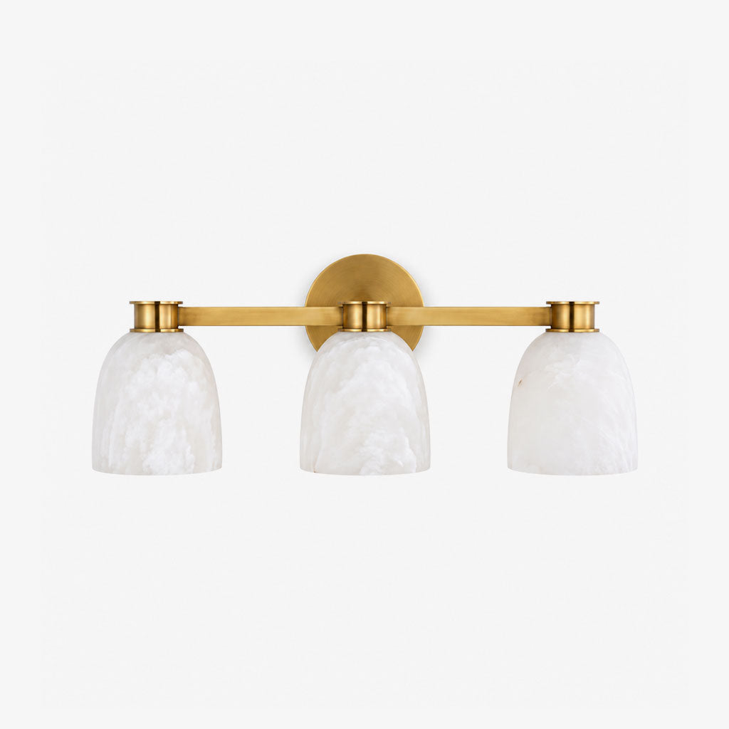 Studio shot of this Clérachic bar sconce in brass finish, three dome alabaster shades on a slim horizontal bar.