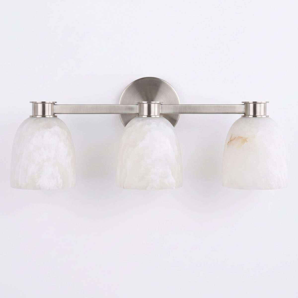 Studio shot of this Clérachic bar sconce in satin nickel finish, three dome alabaster shades set along its bar.