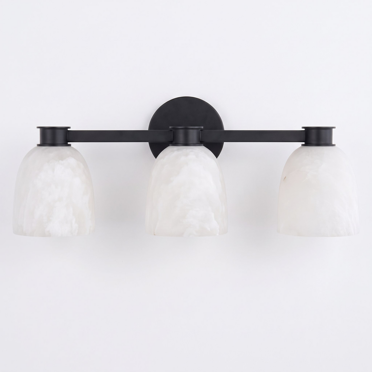 Studio shot of this Clérachic bar sconce in black finish, its three dome shades mounted on a slim bar.