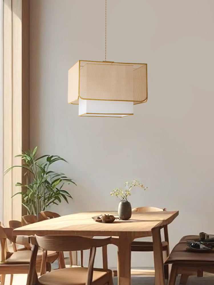 Above a wood dining table and chairs near potted greenery, this Clérachic pendant's lattice shade glows warm.