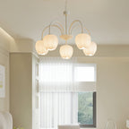 White glass tulip chandelier lit warm above a room