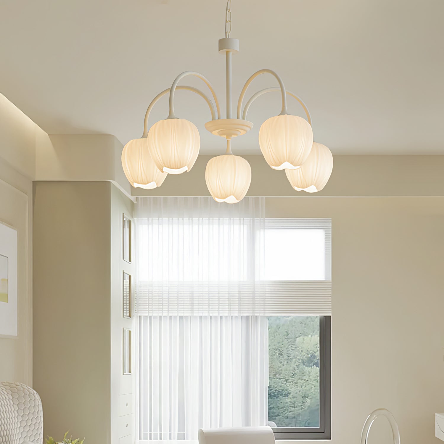 White glass tulip chandelier lit warm above a room