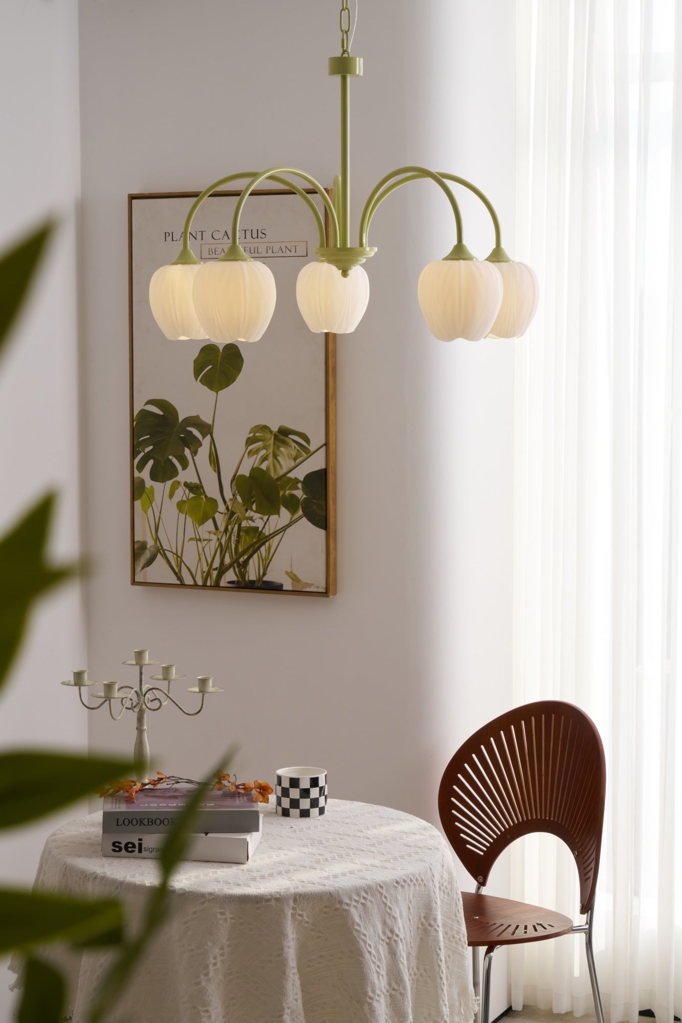 Matcha green tulip chandelier lit in a styled room