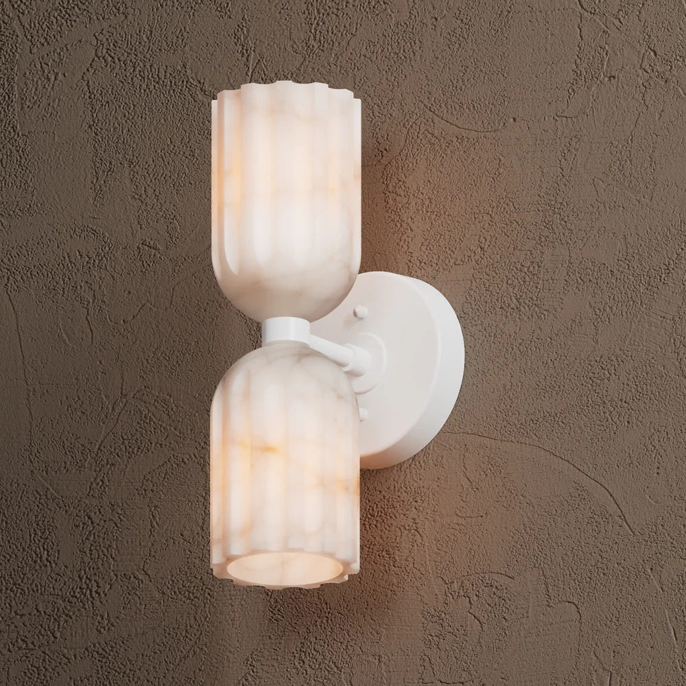 White wall sconce at a three-quarter angle, alabaster shades lit above and below the arm