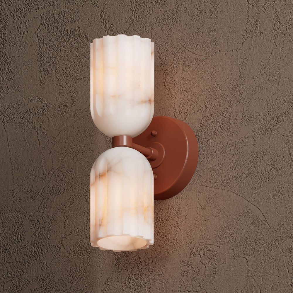 Terracotta sconce viewed from the side, the lower alabaster shade angled down over the wall