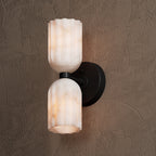 Matte black wall sconce seen at an angle, showing how far the arm projects from the wall