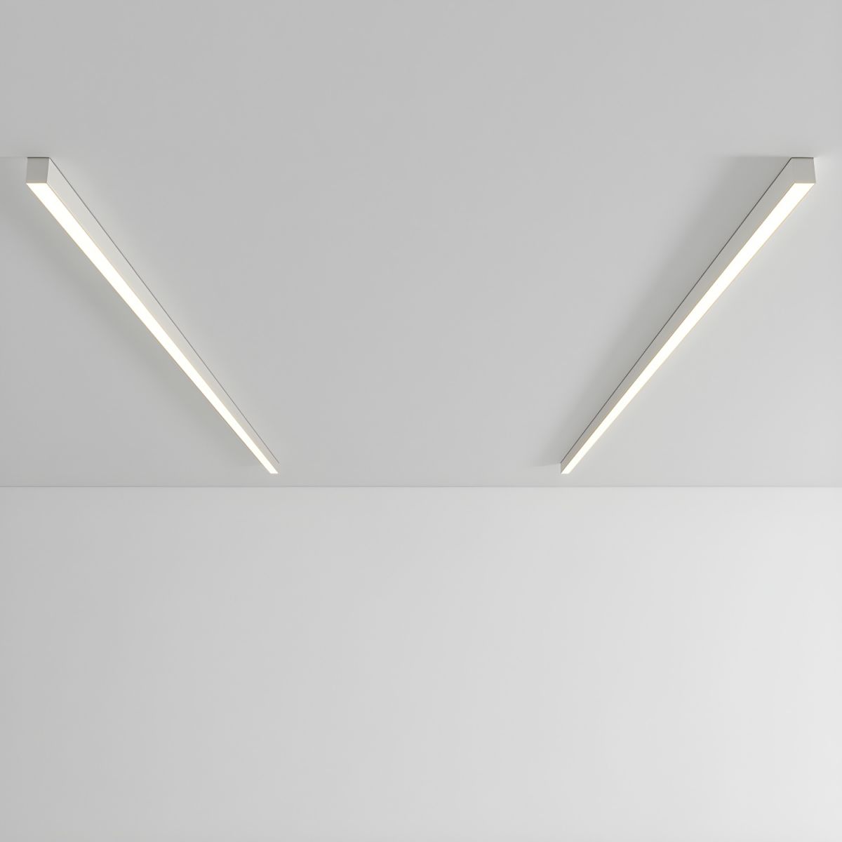 Two white Clérachic ceiling lights angle apart, glowing warmly against a plain grey backdrop.