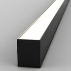 Close view of this Clérachic ceiling light's black profile, its diffuser glowing brightly along its length.