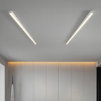 Two black Clérachic ceiling lights glow warmly above a wardrobe wall lit by a strip of cove lighting.