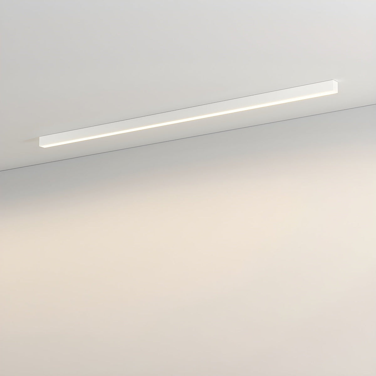 This Clérachic ceiling light in white runs along a plain wall, its diffuser glowing with a warm light.