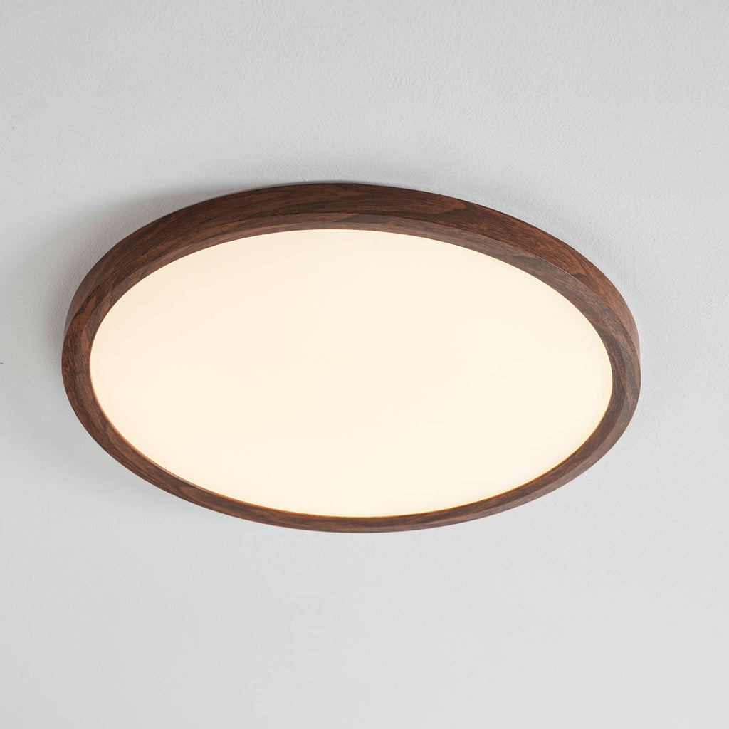 Round ceiling light with wood-grain edge lighting a hallway