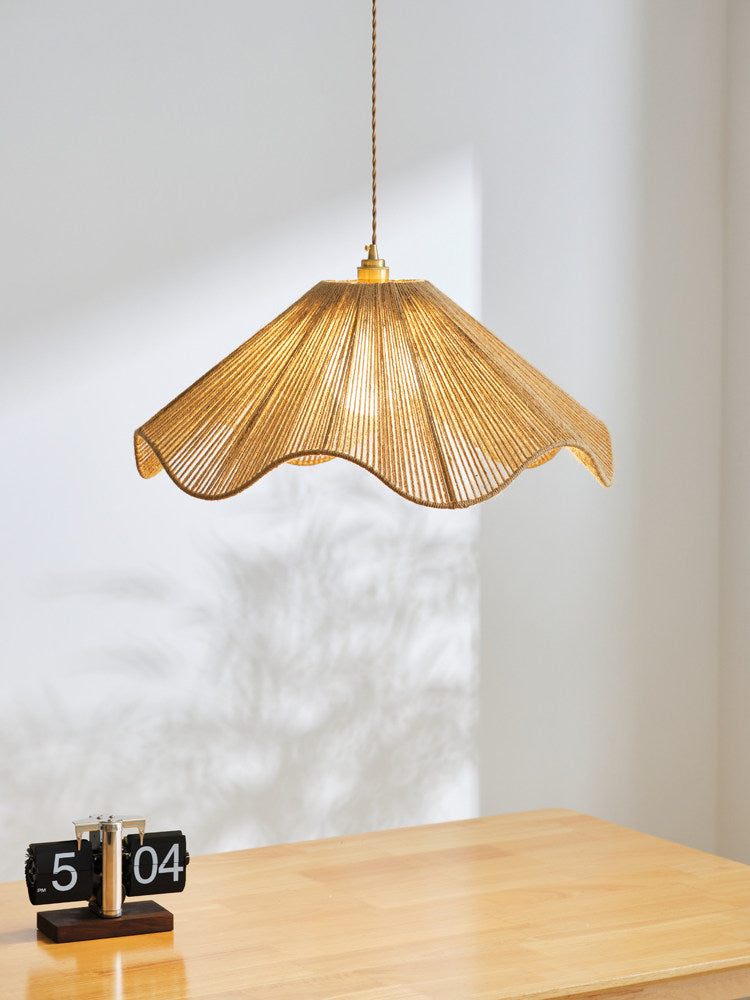 Sunlight streaks the wall as this lit Clérachic pendant hangs above a small wood table holding a flip clock.